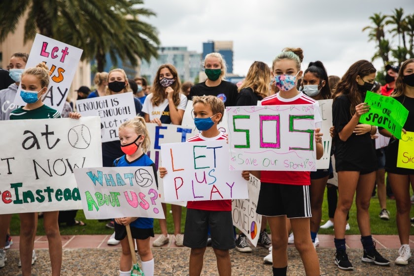 Parents and their children rally in front of the San Diego County Administration to demand to be allowed to play sports. 
